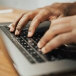 Person typing on a Lenovo laptop keyboard showing how to screenshot on Lenovo laptop
