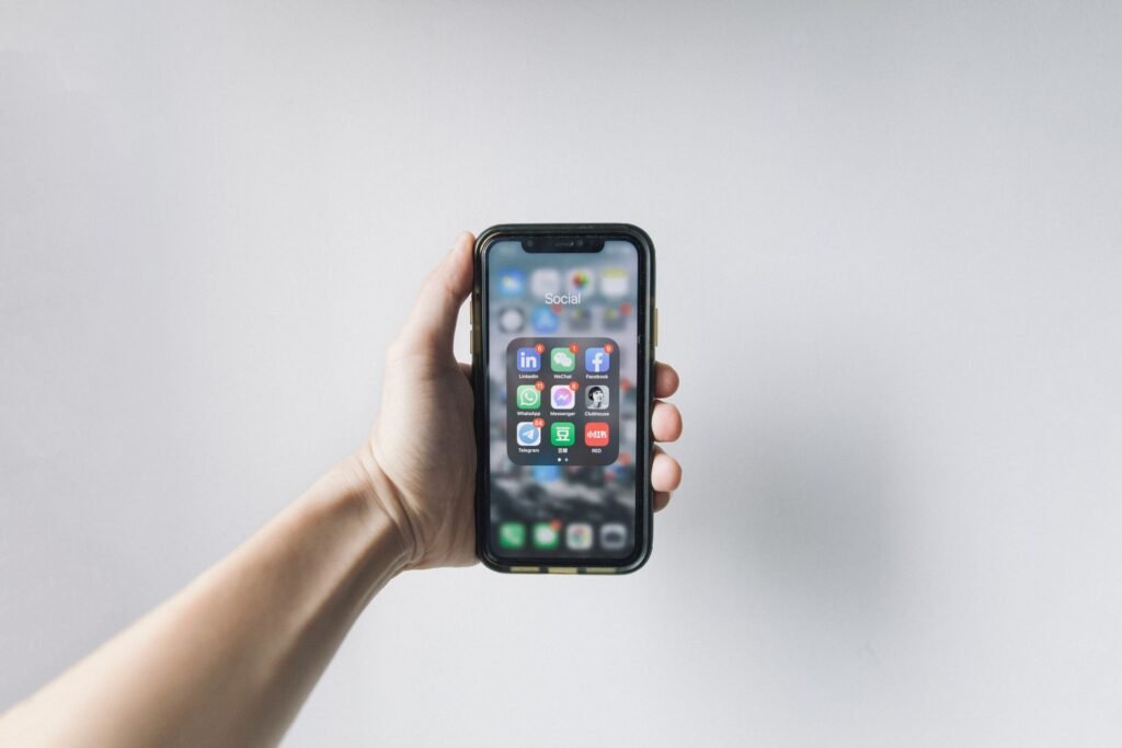 What is a smartphone: hand holding a smartphone showing its home screen