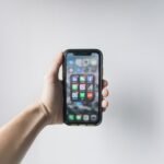 What is a smartphone: hand holding a smartphone showing its home screen
